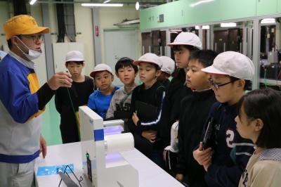 社員の方から製品の説明を受ける児童たち